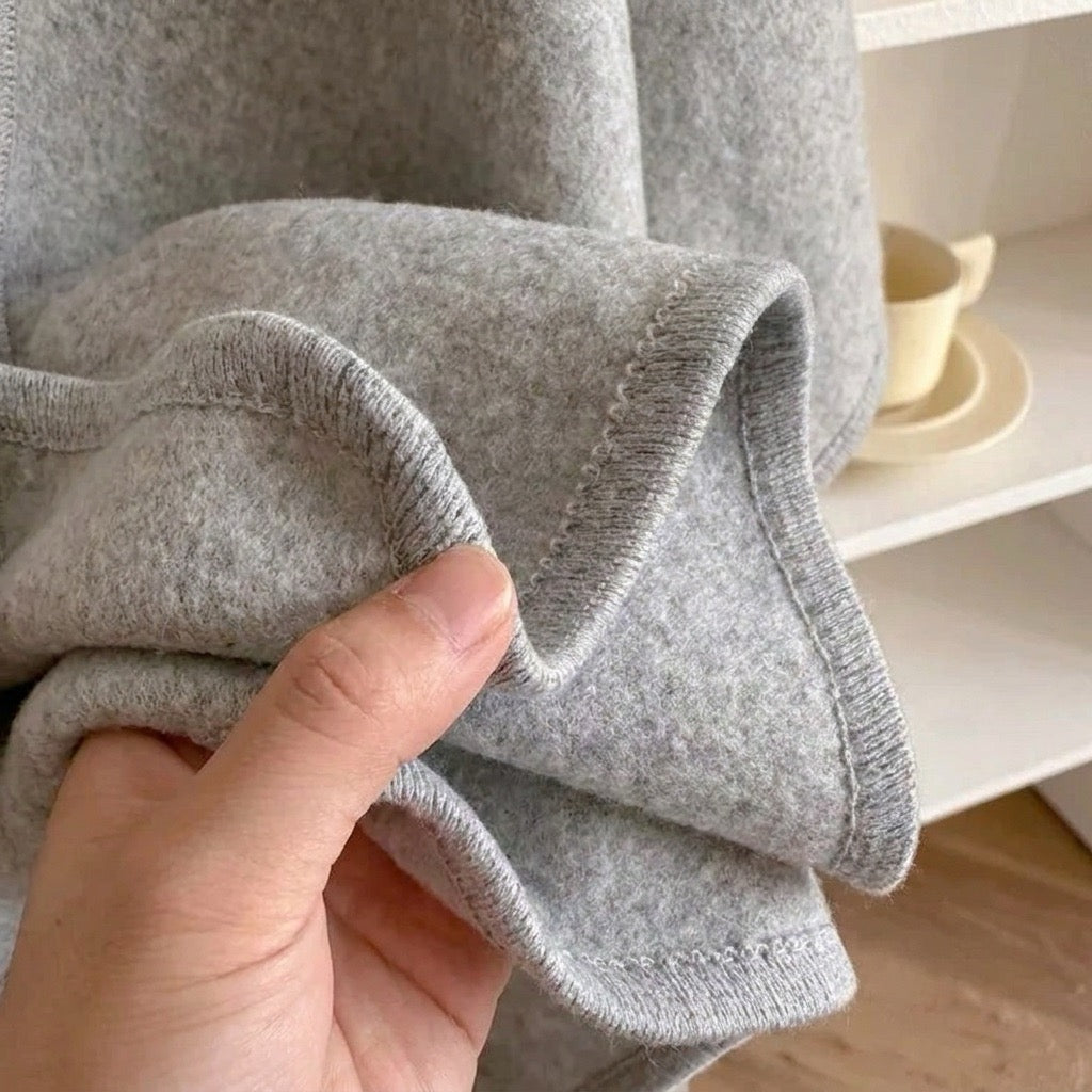 Detalle del tejido del poncho chal largo en gris claro